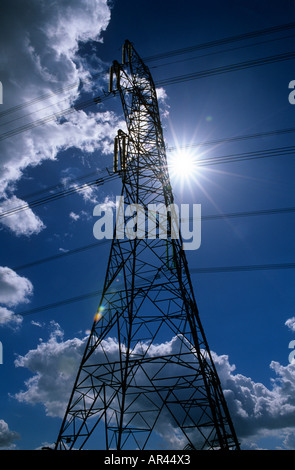 Pylône de l'ÉLECTRICITÉ SUR UN CIEL ASSOMBRI SOMBRE AVEC SOLEIL DERRIÈRE Banque D'Images