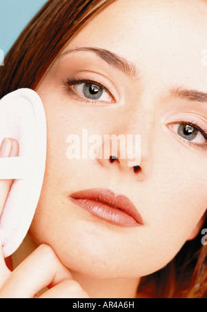 Woman applying make-up Banque D'Images