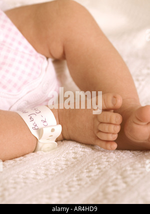 Gros plan sur les pieds et le bracelet d'identité de la jeune fille, petits orteils mignons, Royaume-Uni, Royaume-Uni Banque D'Images