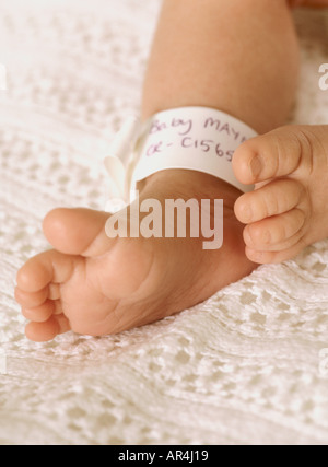 Gros plan sur les pieds et le bracelet d'identité de la jeune fille, petits orteils mignons, Royaume-Uni, Royaume-Uni Banque D'Images