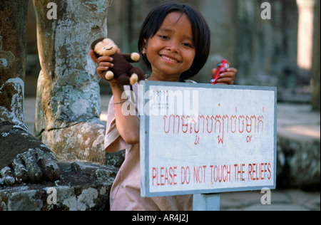 Jan 21, 2003 - Petite fille khmère à un panneau en face de Wat Bayon à Angkor, près de la ville cambodgienne de Siem Reap. Banque D'Images