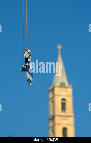 Drapeau israélien attaché à des pierres lancées par des colons juifs qui pendent sur une ligne électrique dans un quartier palestinien à Jérusalem-est Israël Banque D'Images