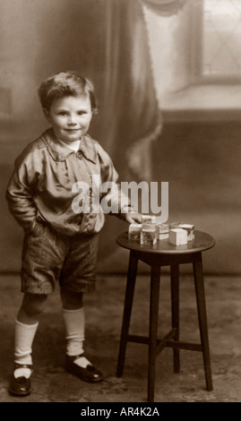 Carte postale portrait Studio d'Edwardian garçon jouet avec des briques, vers 1908, au Royaume-Uni. Banque D'Images