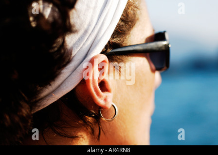 Seule femme d'une trentaine d'années portant un foulard blanc autour de ses cheveux noirs donne sur la mer méditerranée Banque D'Images