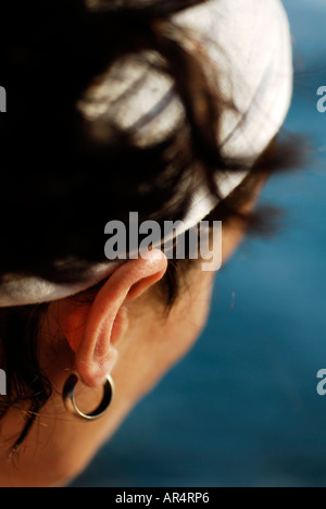 Seule femme d'une trentaine d'années portant un foulard blanc autour de ses cheveux noirs et d'oreille donne sur la mer méditerranée Banque D'Images