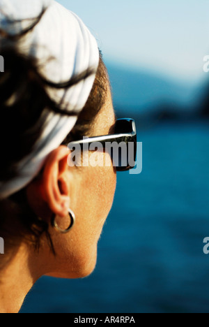 Seule femme d'une trentaine d'années portant un foulard blanc autour de ses cheveux noirs donne sur la mer méditerranée Banque D'Images