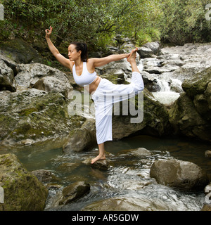 Asian American woman doing yoga équilibre sur Boulder Creek à Maui Hawaii par Banque D'Images