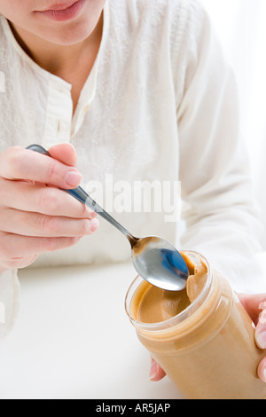 L'écopage femme de beurre d'arachide jar Banque D'Images