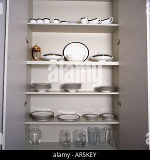Portes Fenêtres s'ouvrent sur de la vaisselle blanche sur étagères blanches en alcôve cachée placard Banque D'Images
