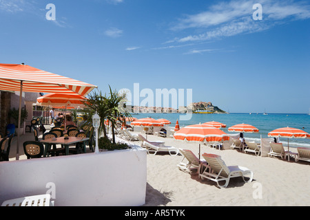 Plage et bar de plage avec la ville et citadelle de la distance, La Balagne Calvi, Corse, France Banque D'Images
