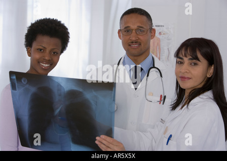 Les médecins multi-ethnique et patient looking at x-ray Banque D'Images