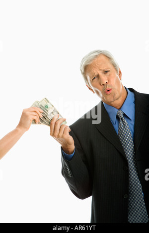 Femme tenant de l'argent avec Caucasian middle aged businessman faisant l'expression faciale Banque D'Images