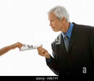 Caucasian middle aged businessman pulling one hundred dollar bill de femme Banque D'Images