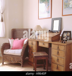 Rose blanc coussins sur l'osier fauteuil à côté de Old pine 24 et selles en petite étude Banque D'Images