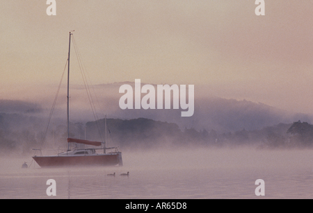 Misty vue du bateau sur le lac à l'aube de Windemere Point Cockshott Banque D'Images