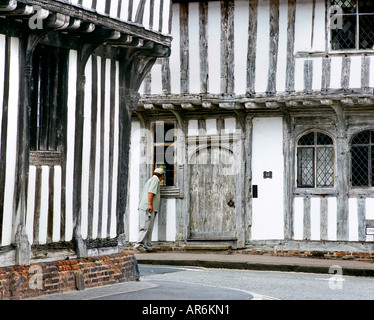 Touriste nosy jetant un coup d'œil dans les vieux bâtiments à colombages à School Lane, Lavenham, Suffolk. Banque D'Images