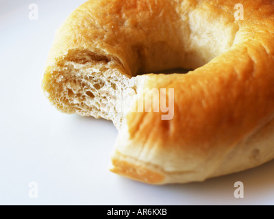 La farine blanche (régulier) bagel contre fond blanc avec un morceau pris hors de lui. Banque D'Images