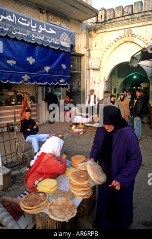 Femme musulmane Vente de pain dans les rues de Tanger Maroc afrique du vendeur Banque D'Images