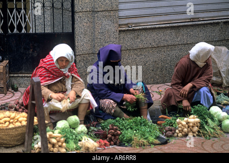 Femme musulmane avec tête couverte dans les rues vendant des légumes en Afrique Maroc Tanger Banque D'Images