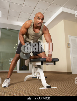 Mixed Race man lifting weights Banque D'Images