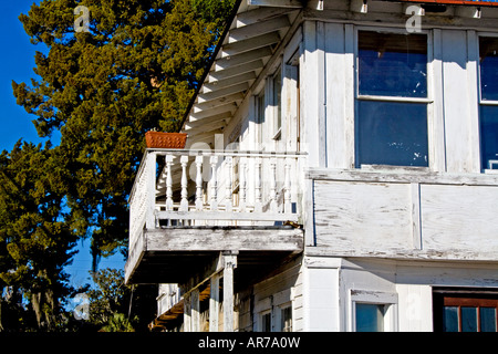 Le semoir sur un balcon sur une vieille maison blanche déserte. Banque D'Images