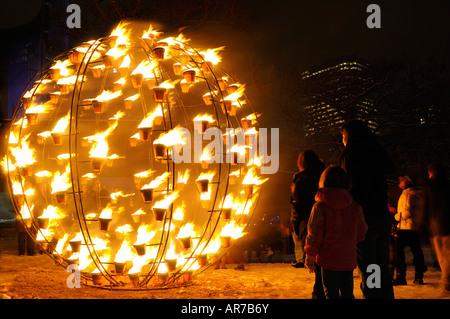 Mère et enfants regardant globe flamboyant sur la neige à wintercity Nuits de feu toronto Banque D'Images