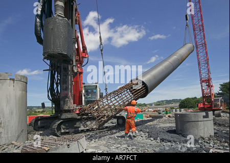 Le levage cage acier renforcé en un tas d'excavation. Le béton sera coulé dans le boîtier d'achever cette pile. Banque D'Images