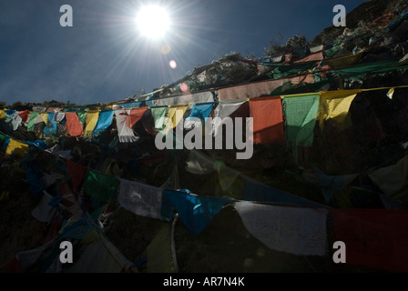 Drapeaux de prière voir pris en le soleil sur les pèlerins au monastère de Ganden, Tibet Kora Banque D'Images