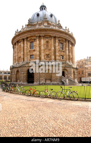 Bicyclettes enchaîné à la clôture de la Radcliffe Camera édifice qui abrite la bibliothèque bodléienne de l'Université d'Oxford. Banque D'Images