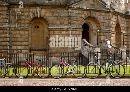 Bicyclettes enchaîné à la clôture de la Radcliffe Camera édifice qui abrite la bibliothèque bodléienne de l'Université d'Oxford. Banque D'Images