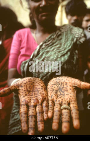 Une femme indienne affiche la version de droite hindoue de la croix gammée sur ses paumes. important dans la religion hindoue comme un symbole de chance. Banque D'Images