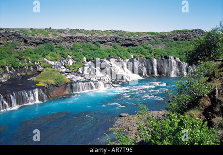 Hraunfossen chute se déversant du dessous de la pierre de lave volcanique en champ bleu magnifique rivière Hvita dans l'ouest de l'Islande Banque D'Images