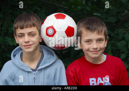 Deux garçons de football d'équilibrage, les bras croisés, Close up Banque D'Images