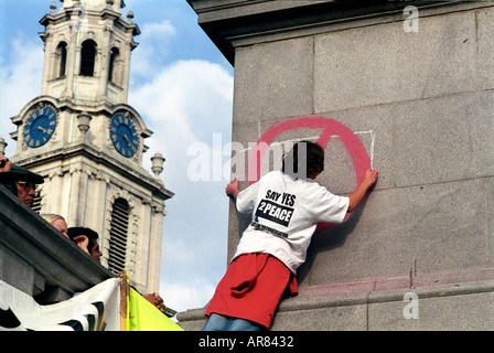 Jeune garçon écrit à la craie sur le côté d'une statue à Trafalgar square, lors d'une manifestation Banque D'Images