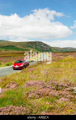 Monts Wicklow Wicklow Hills, en Irlande. Voiture rouge conduite sur route de montagne dans 5 miles NW de Laragh venant de Sally Gap. Banque D'Images