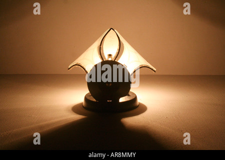 L'ombre de lampe jette une lueur chaude sur le mur à l'intérieur d'une maison - vu du dessous Banque D'Images