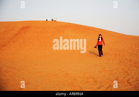 Femme marchant sur une dune de sable Banque D'Images