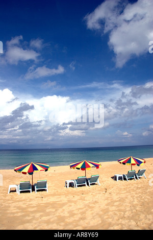 Trois parasols de plage ouvert sur une plage de Karon, sur la côte ouest de Phuket sur une parfaite journée ensoleillée avec des nuages blancs Banque D'Images