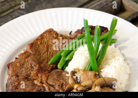 Ribeye cuit avec du riz, farine de haricots verts et les champignons sur une plaque blanche Banque D'Images