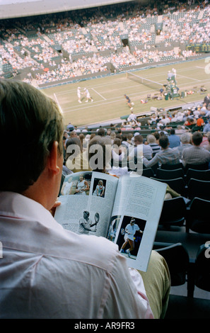 Man reading a magazine pendant un match de tennis sur le court de Wimbledon 2006 personne Wimbledon London England Banque D'Images