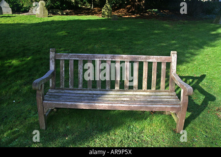 Vieux banc dans le cimetière de l'église Holy Trinity Minchinhampton Gloucestershire Banque D'Images