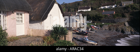 Cadgwith Cove avec des chalets et bateaux établi sur la plage Cornwall Banque D'Images