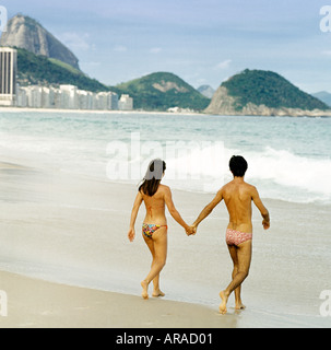 Jeune couple en marche de surf à la plage de Copacabana à Rio de Janeiro Brésil Amérique du Sud Banque D'Images