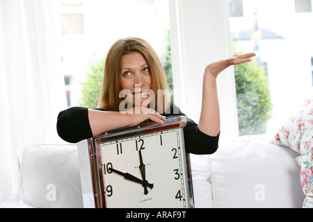 En retard, woman holding horloge fonctionne tard et s'inquiète Banque D'Images