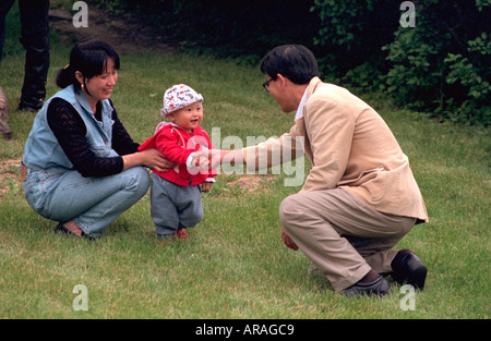 Asian family l'âge de 30 et 1 l'apprentissage de la marche dans le parc, au service du Memorial Day. St Paul Minnesota MN USA Banque D'Images