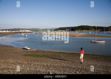 Femme à la recherche sur les bateaux à marée basse dans l'estuaire de Conwy Deganwy avec Château de Conwy et le pont en arrière-plan de Galles UK Banque D'Images