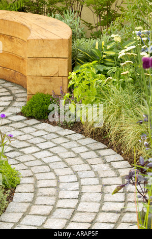 Flower Show Tatton chemin de galets incurvée avec banc en bois planté de hosta achillea et diverses graminées Banque D'Images