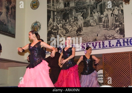 Trois femmes en robes colorées danser le flamenco, Séville, Andalousie, Espagne Banque D'Images