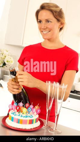 Fille avec champagne et gâteau d'anniversaire Banque D'Images