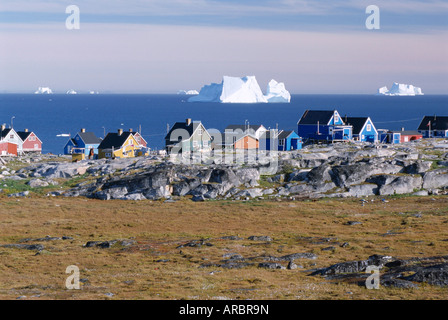 Maisons de village peint en face d'icebergs dans la baie de Disko, Oeqertarsuaq (Godhavn), l'île Disko, côte ouest, Groenland Banque D'Images